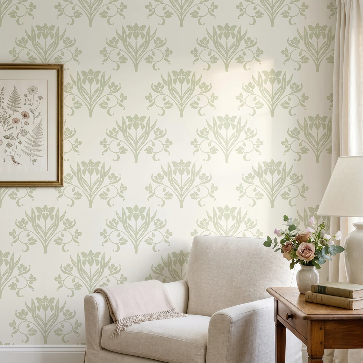 Liria, papel pintado floral verde salvia y marfil, a escala grande en salón luminoso con butaca, decorado con cuadros y elementos vegetales.