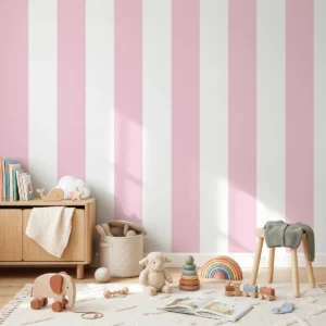 Modelo Della, papel pintado de rayas rosa rubor y blanco, a escala maxi en habitación infantil luminosa y ordenada con una decoración en tonos neutros y madera clara, con un mueble bajo de madera con libros, un taburete pequeño, cestas de almacenamiento y varios juguetes esparcidos sobre una alfombra clara con un patrón suave, creando un ambiente acogedor y moderno.