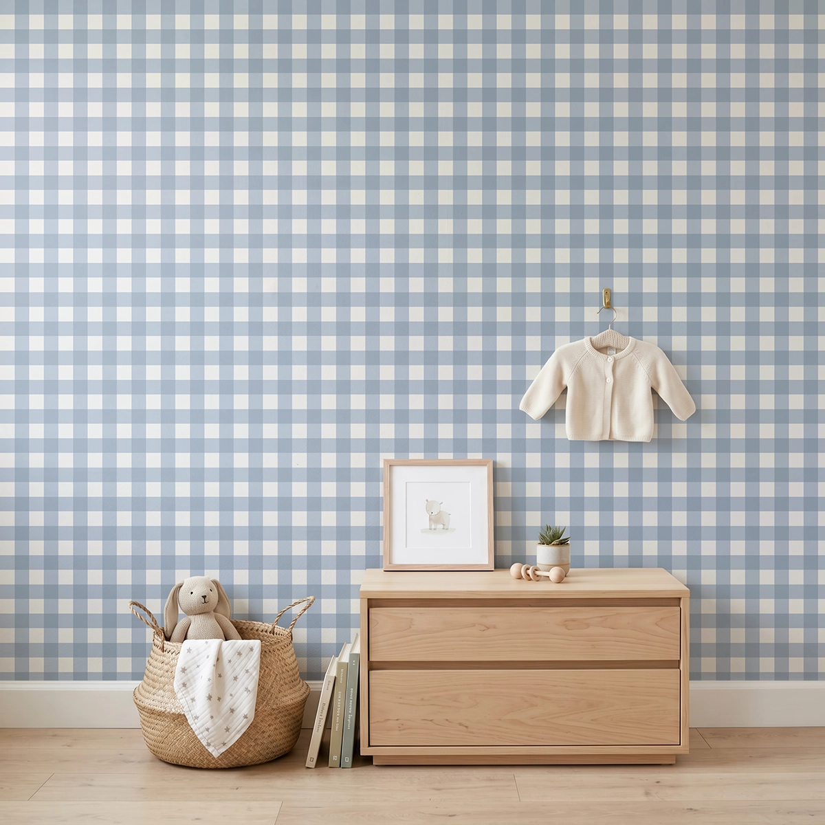 Anna, papel pintado Vichy azul empolvado y blanco lino, a escala pequeña en habitación infantil con cómoda, elementos decorativos y mobiliario de estilo natural.