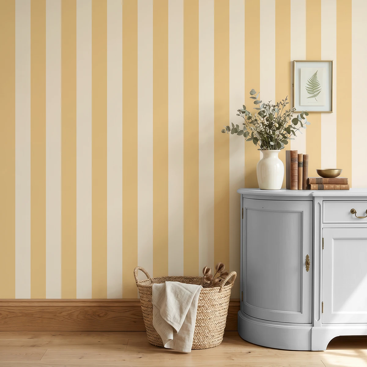 Modelo Della, papel pintado de rayas albaricoque y crema, a escala grande en cocina luminosa con mueble bajo de madera con jarrón con flores y con un cesto de esparto.