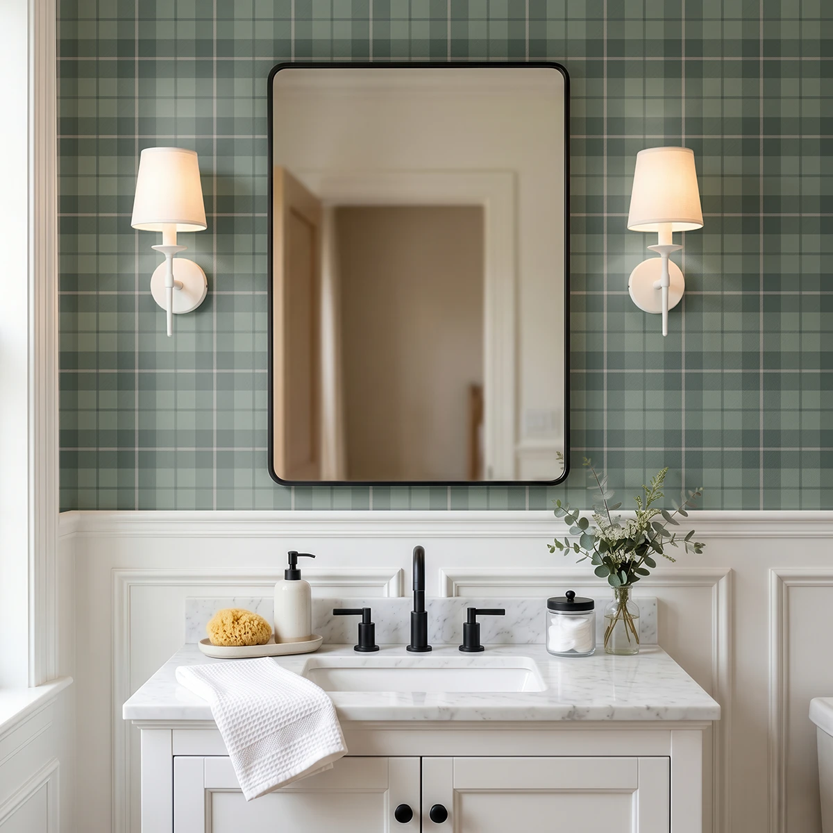 Modelo Oscar, papel pintado tartán verde bosque y gris, a escala pequeña en baño clásico con mueble de lavabo y espejo cuadrado a cuyos lados se sitúan unos apliques de luz clásicos y elegantes..