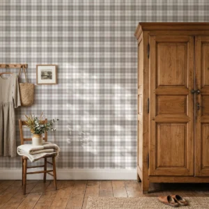 Modelo Oscar, papel pintado tartán taupé y berenjena, a escala pequeña en pared en habitación de estilo rústico con armario y silla de madera y una percha en la pared de la que cuelgan unas prendas.